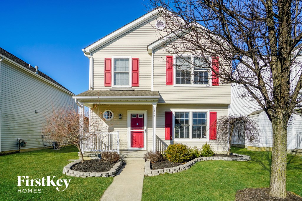 A house with a red door and red shutters is for sale.