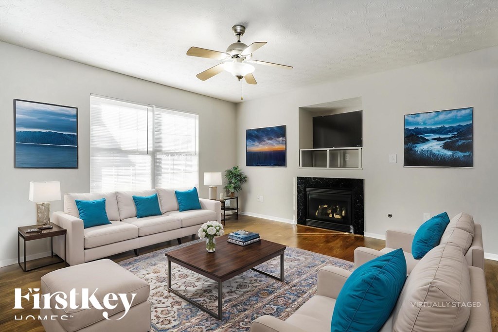 A living room with a couch, a coffee table, and a fireplace.