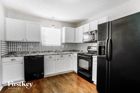 a kitchen with black appliances and white cabinets