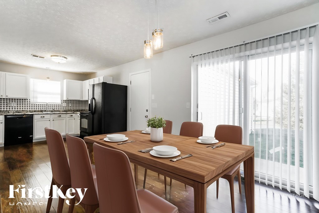 A dining room with a wooden table and chairs.