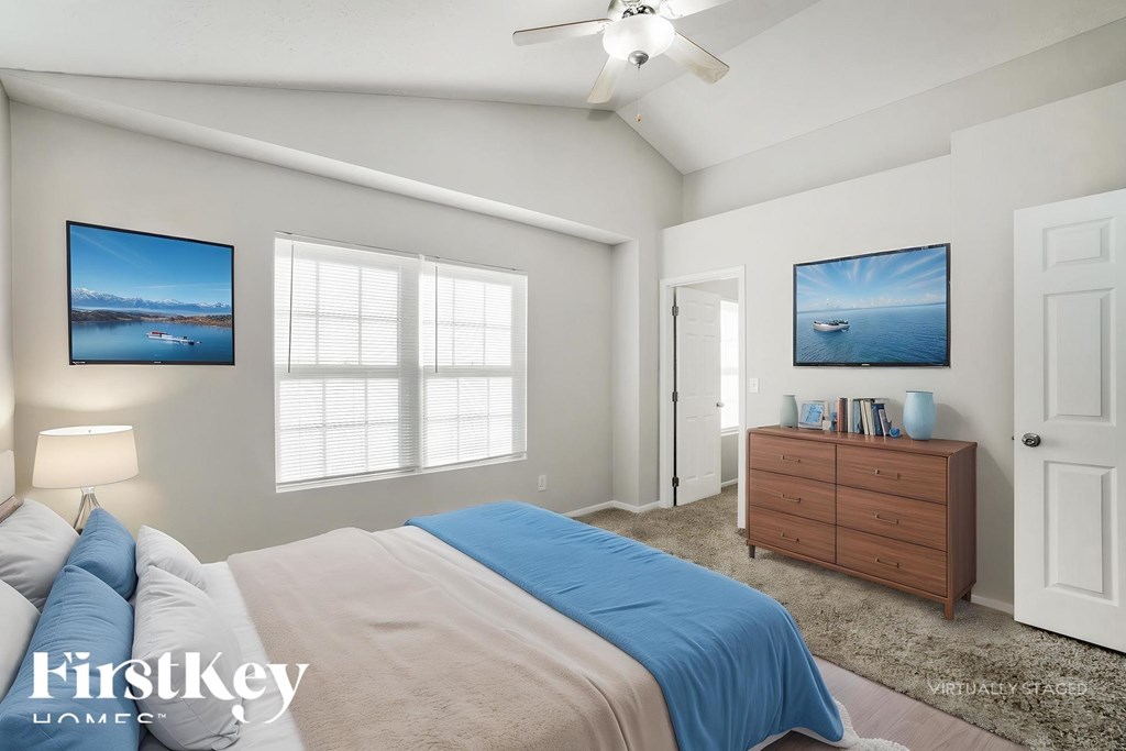 A bedroom with a bed, dresser, and two pictures on the wall.
