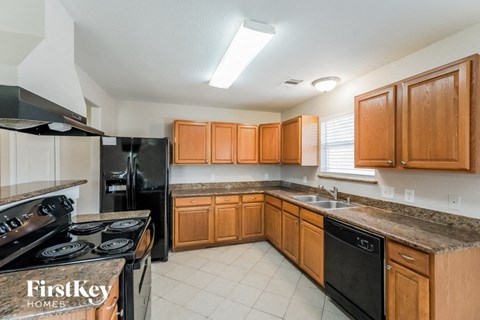A kitchen with wooden cabinets and black appliances.
