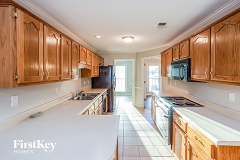 A kitchen with wooden cabinets and a black refrigerator.