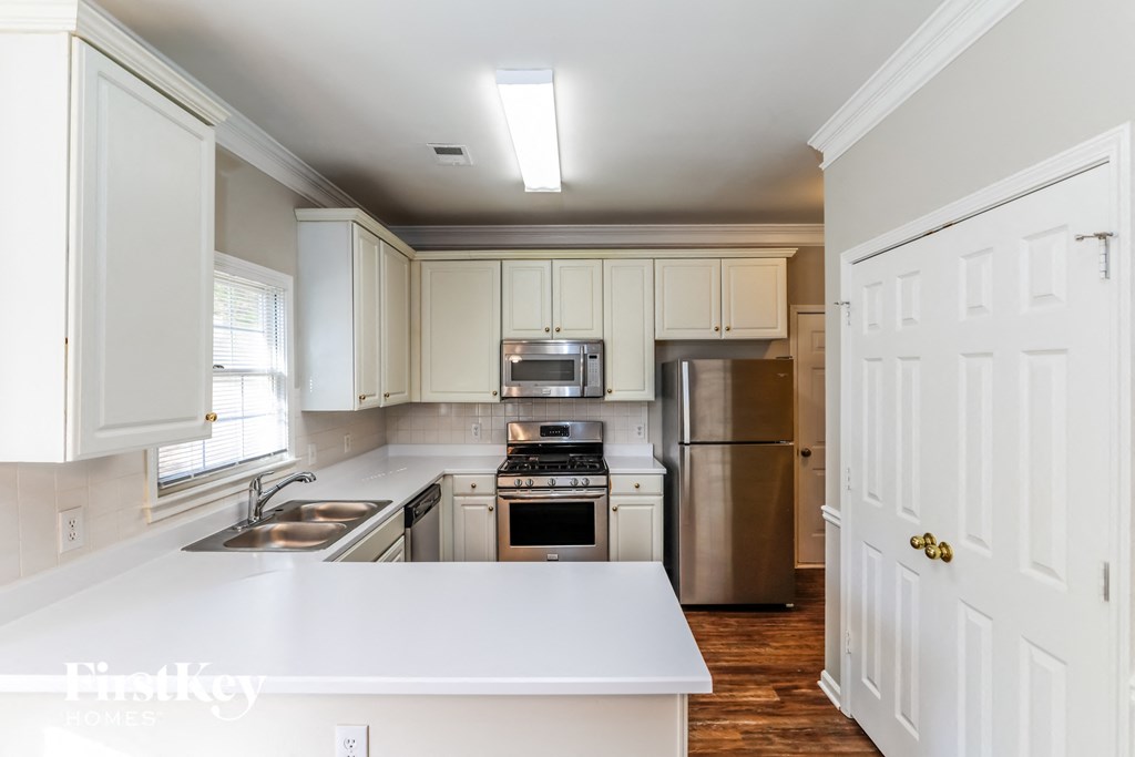 a kitchen with white cabinets and stainless steel appliances