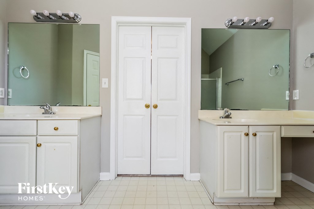 a bathroom with two sinks and a mirror and a closet