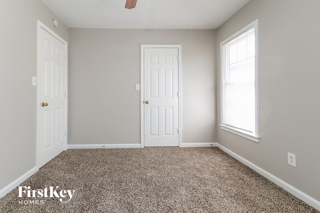a bedroom with a carpeted floor and two white doors