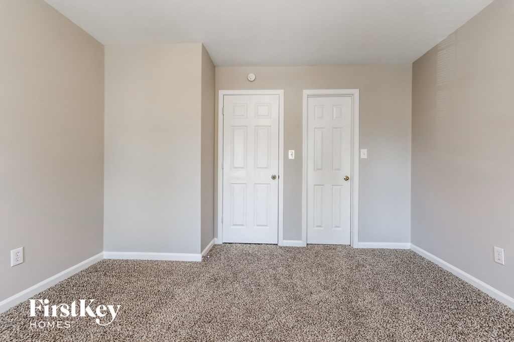 a empty room with two doors and a carpet floor