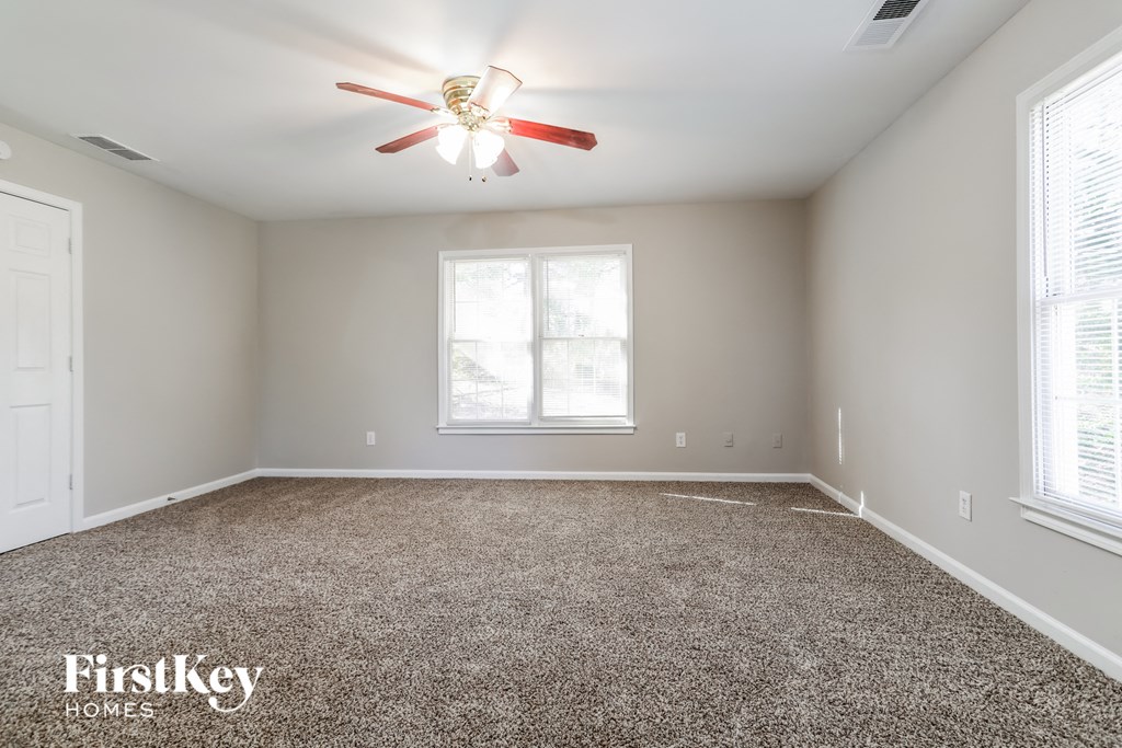 a bedroom with a carpeted floor and a ceiling fan