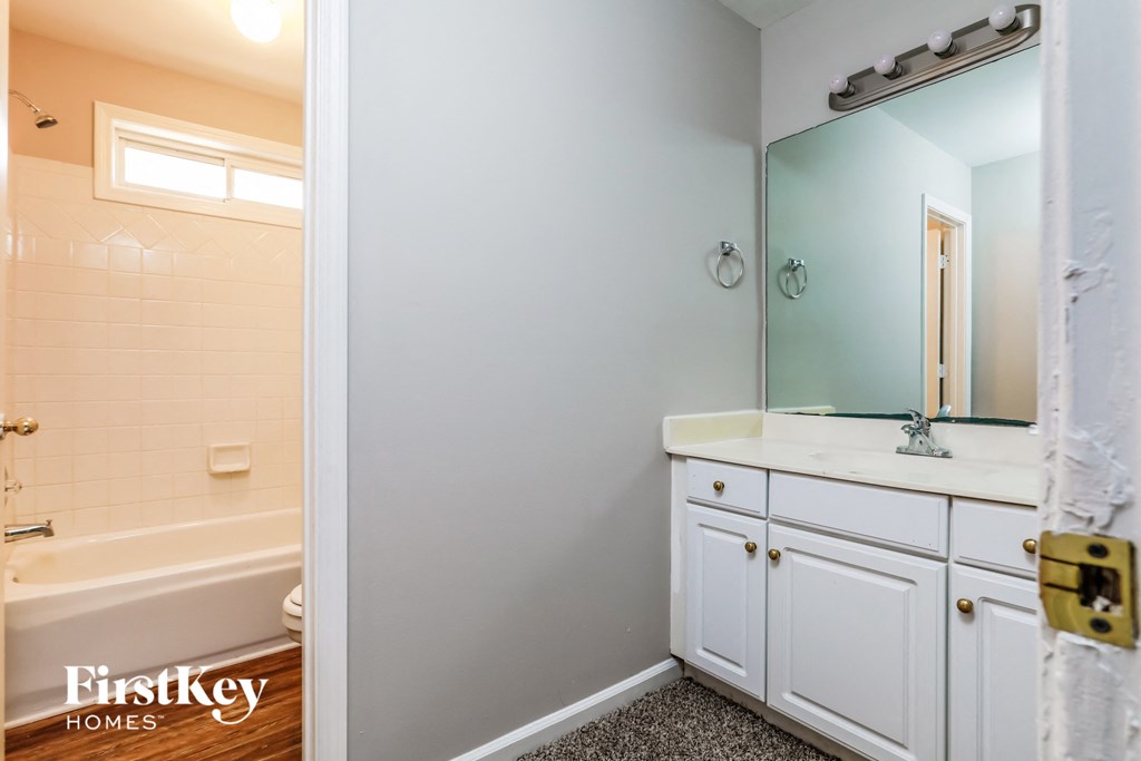 a bathroom with a sink and a tub and a mirror