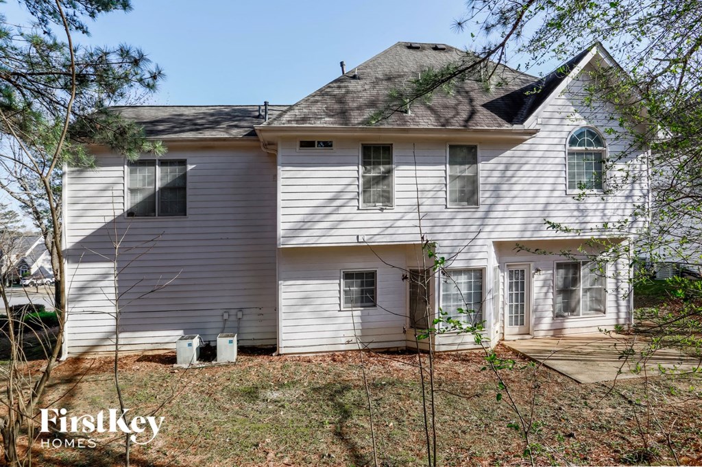 a white house with a gray roof and some trees