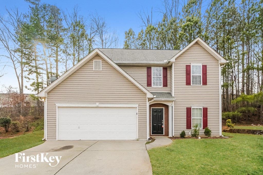 A house with a garage and a driveway in front of it.