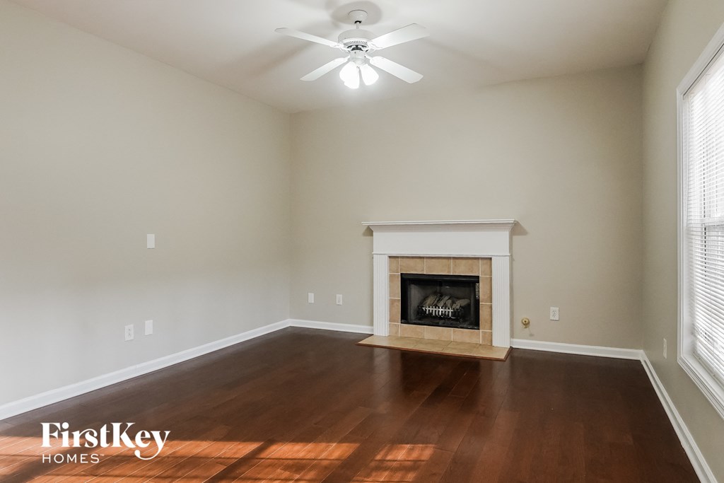 A room with a fireplace and a ceiling fan.