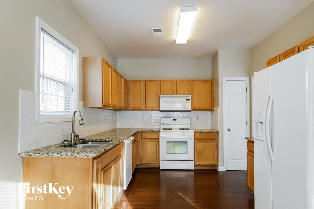 A kitchen with wooden cabinets and a white fridge.
