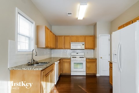 A kitchen with wooden cabinets and a white fridge.