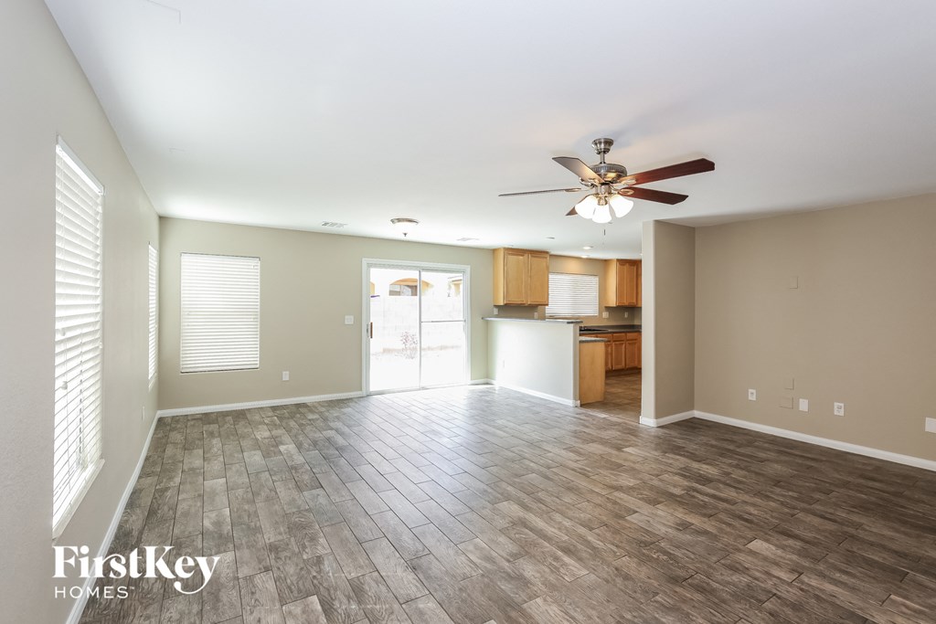 A spacious room with a ceiling fan and wooden flooring.