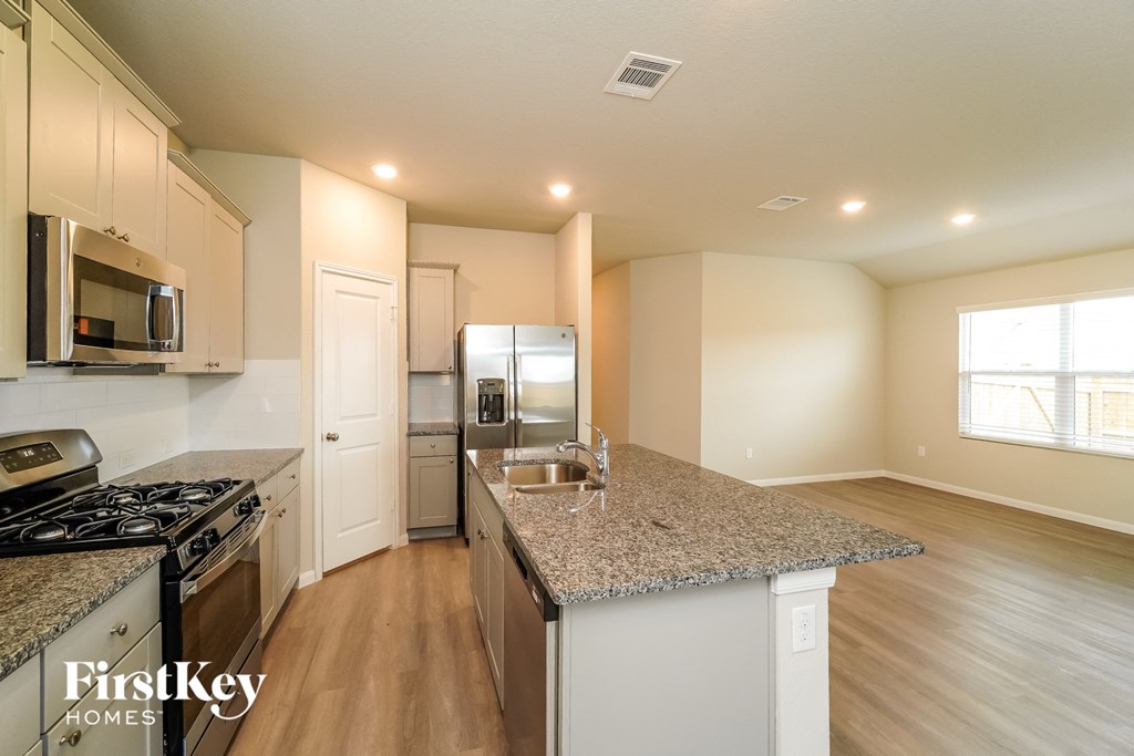 A kitchen with granite countertops and stainless steel appliances.