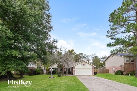 a house with a driveway and a yard with trees
