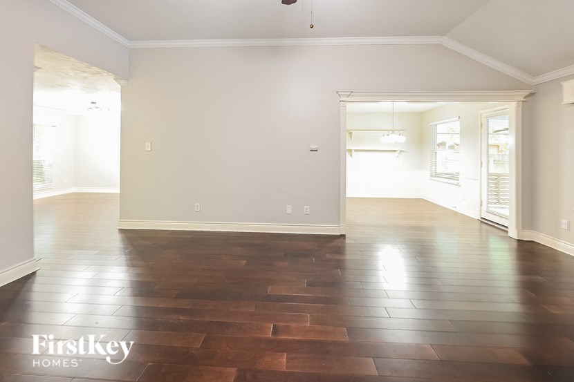 an empty living room with wood floors and white walls