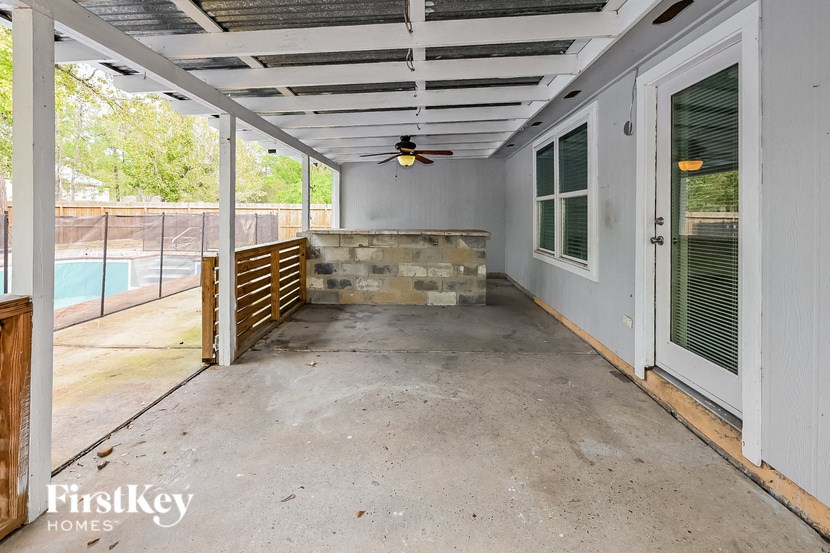 a covered patio with a pool and a door