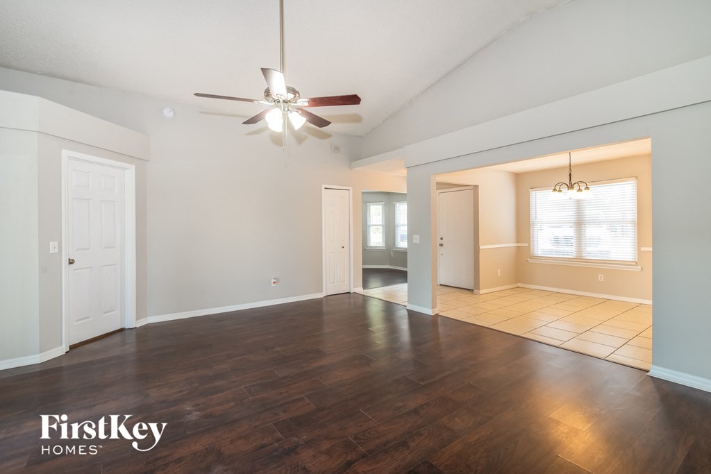 the living room of an empty house with a ceiling fan