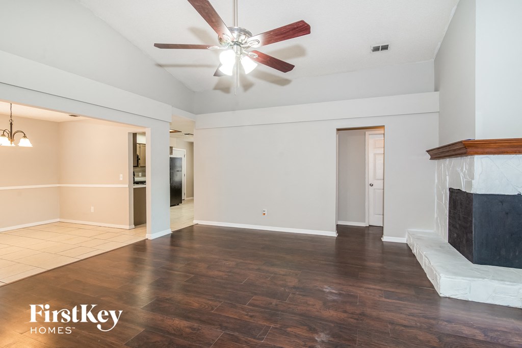 a living room with a fireplace and a ceiling fan