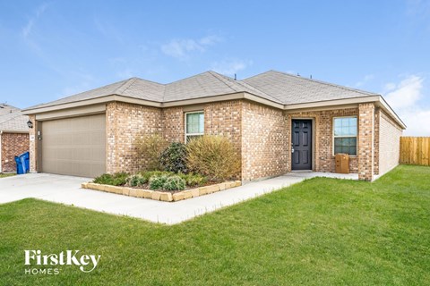 a brick house with a lawn and a driveway
