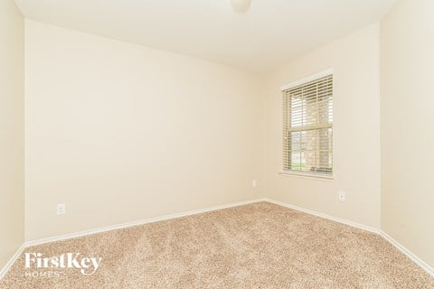 a spacious room with carpet and a window