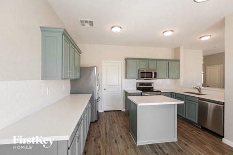 A kitchen with a white counter top and a white fridge.