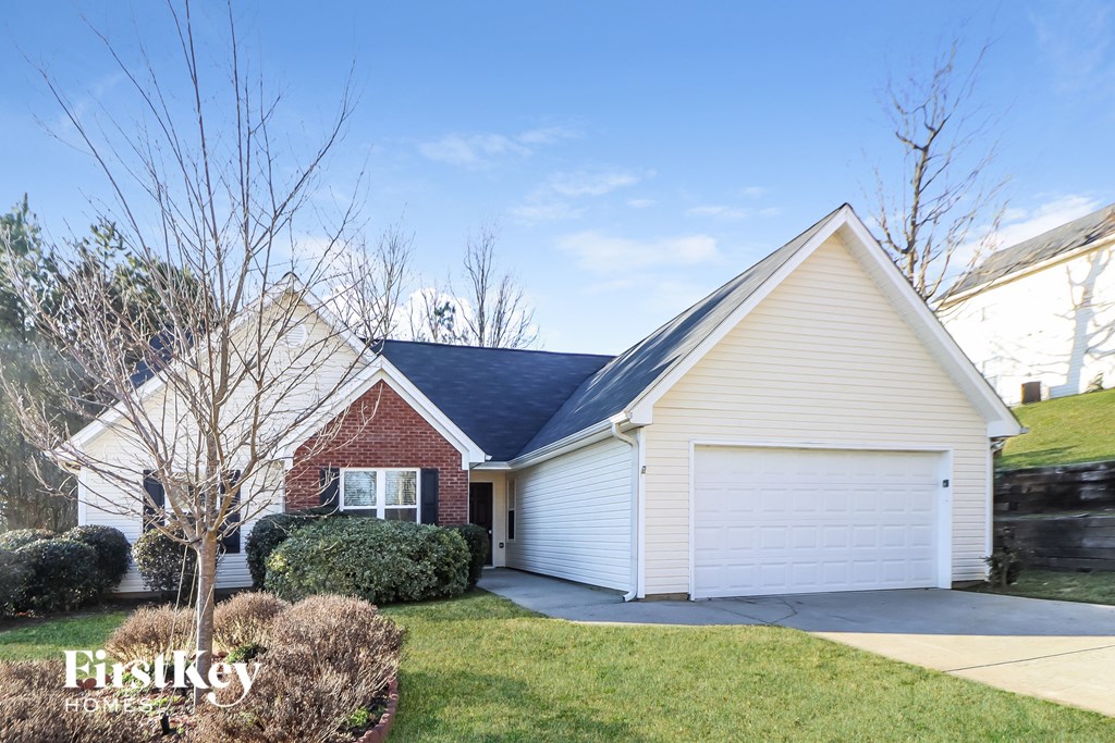 front view of a white and brick house with a garage