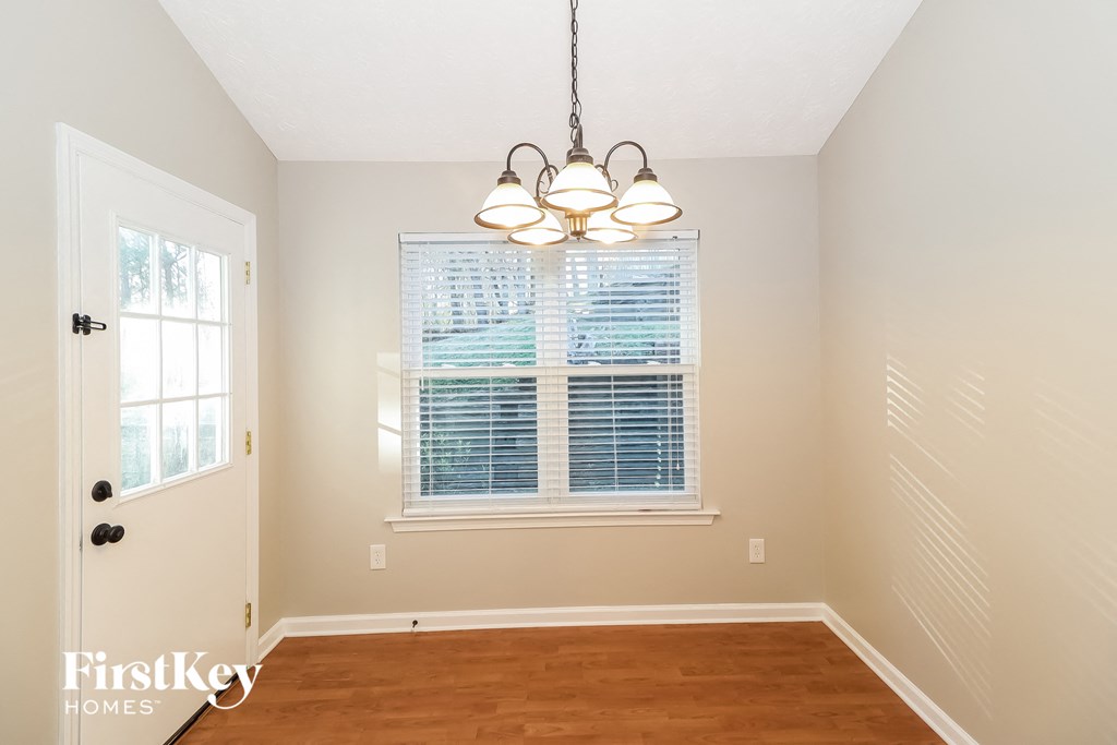 a bedroom with a large window and a chandelier