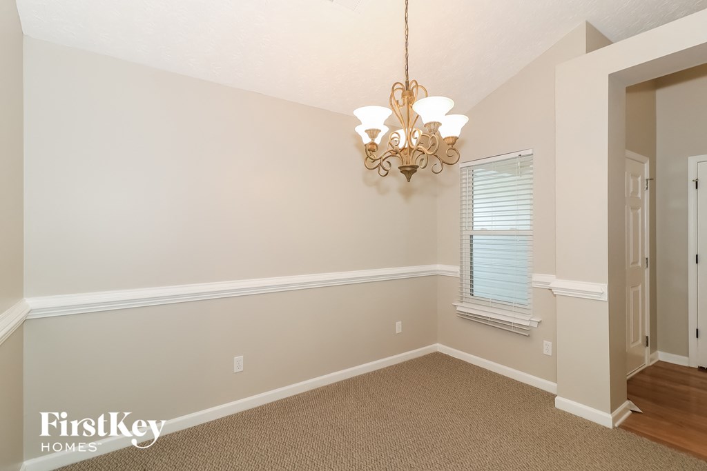 a dining room with a chandelier and a window