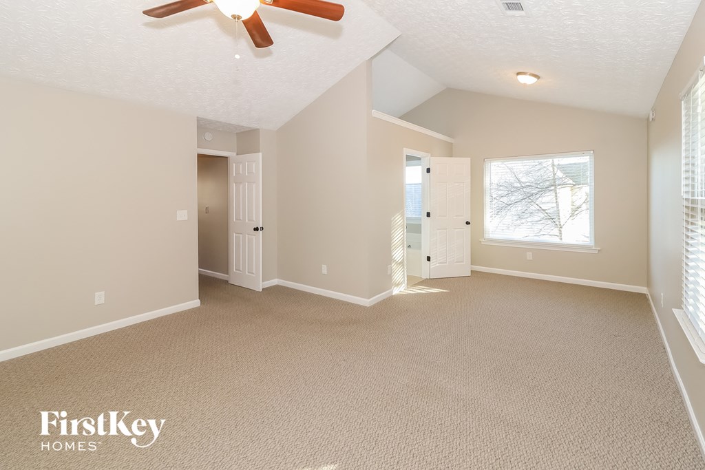 a living room with carpet and a ceiling fan