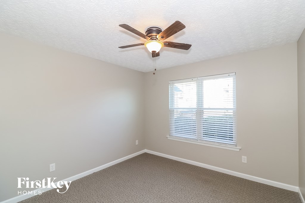 a bedroom with a ceiling fan and a window
