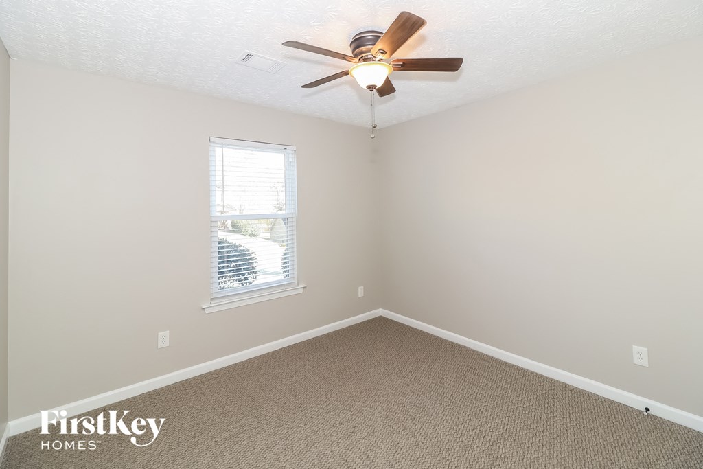 a bedroom with a ceiling fan and a window