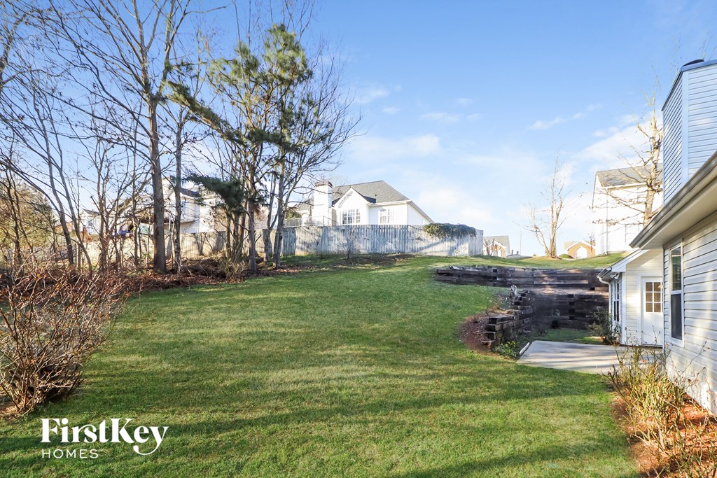 a backyard with a yard and a fence and a house