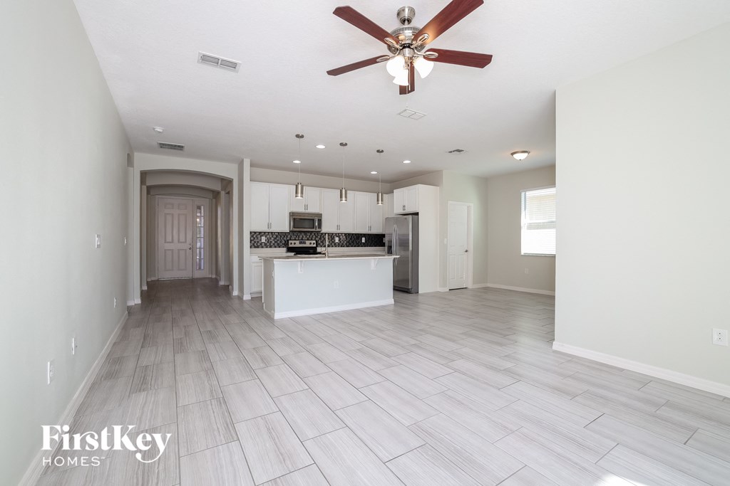 an open kitchen and living room with a ceiling fan
