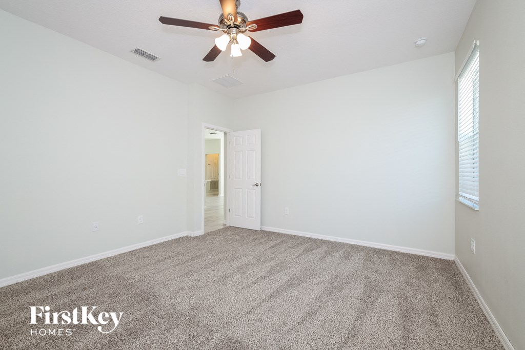 the living room has a ceiling fan and a carpeted floor