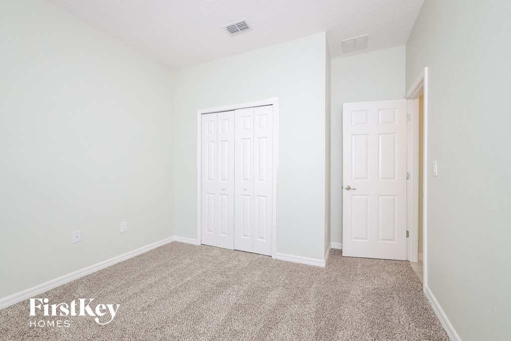 a bedroom with two white doors and a carpeted floor