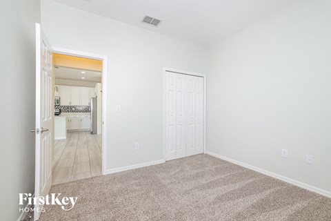 a living room with carpet and a door to a kitchen