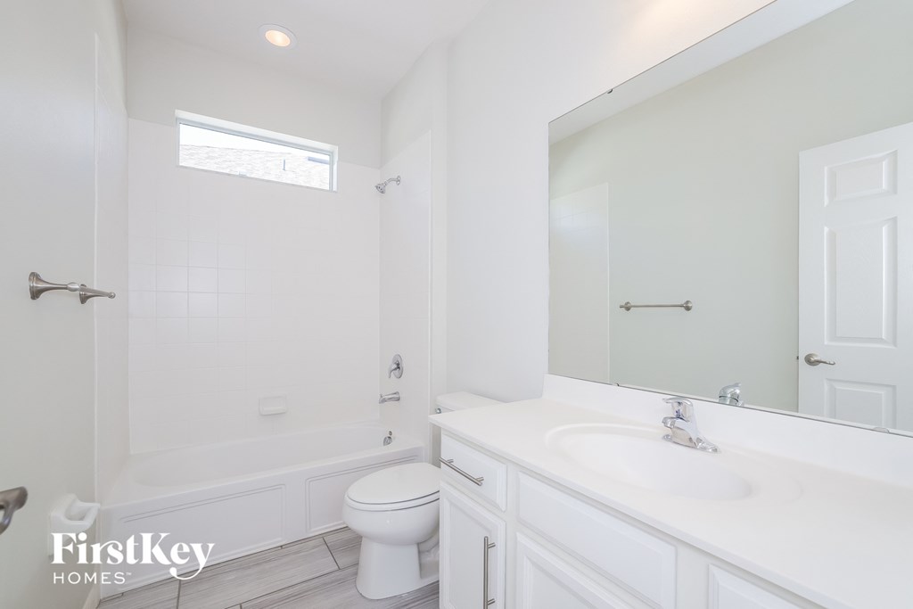 a white bathroom with a sink and a toilet and a tub
