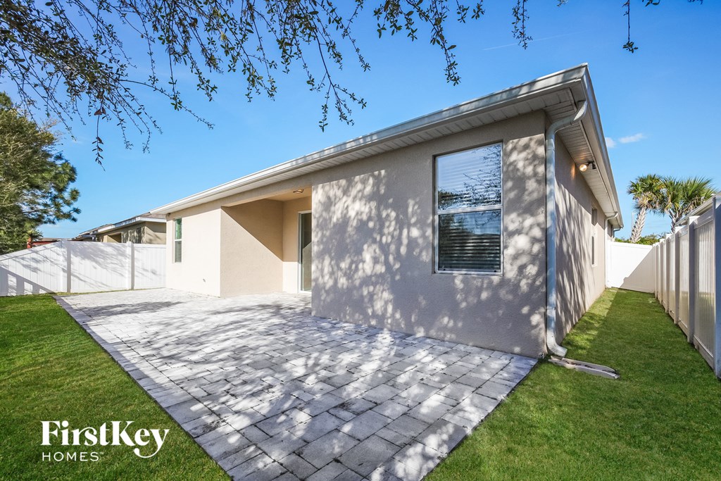 a white house with a driveway and a white fence