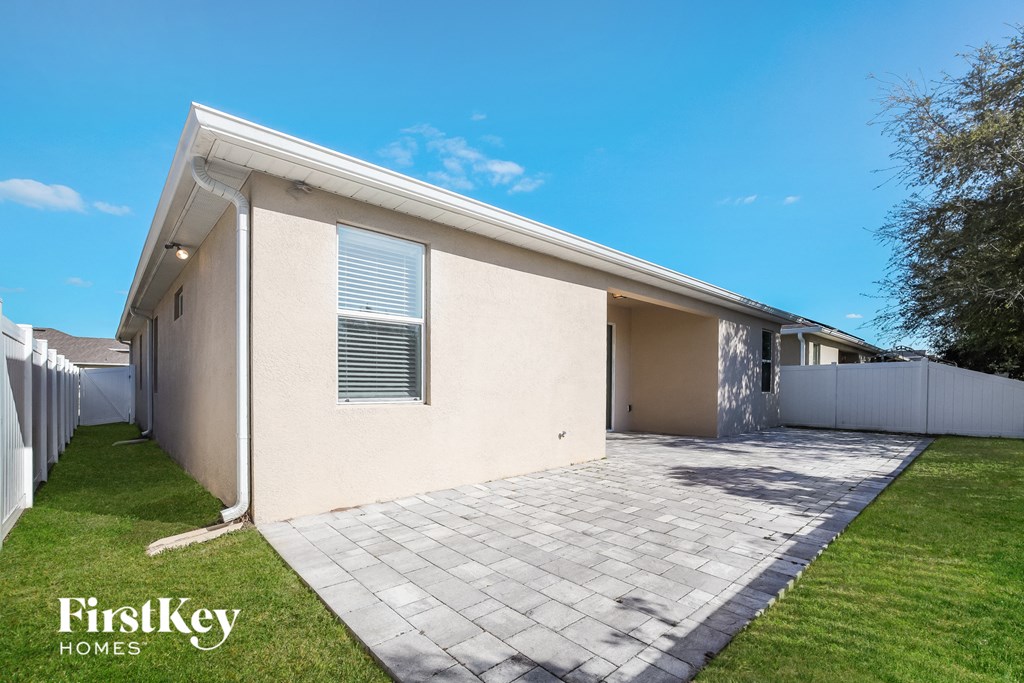 a small white house with a driveway and a lawn