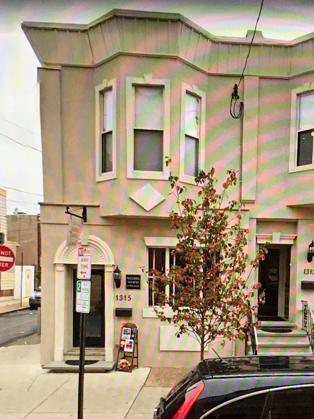 A building with a black car parked in front of it.