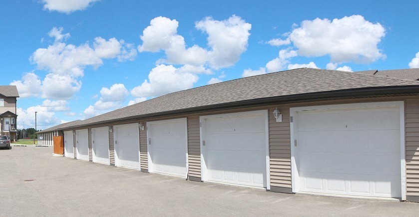 a row of white garage doors on a building