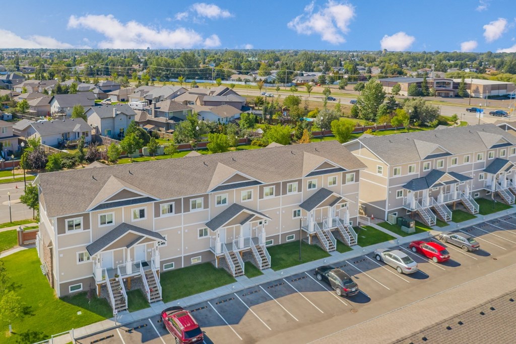 an aerial view of a large building with cars parked in front of it