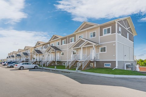 a row of houses with cars parked in front of them