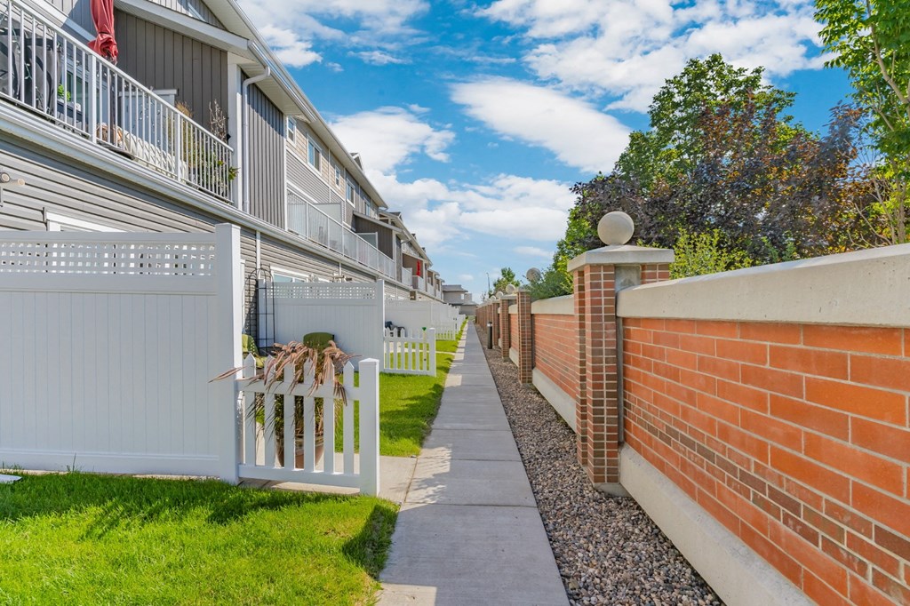 an empty sidewalk in front of a row of houses