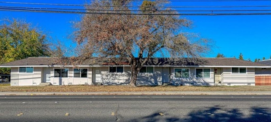 a white house with graffiti on the side of the street