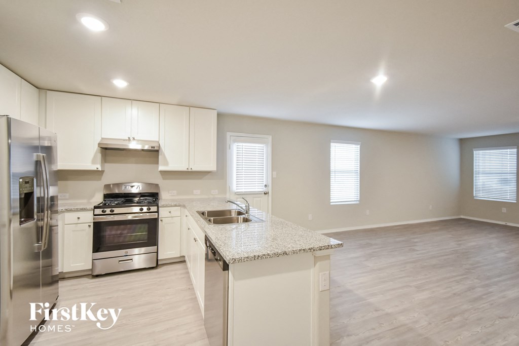 a kitchen with white cabinets and stainless steel appliances