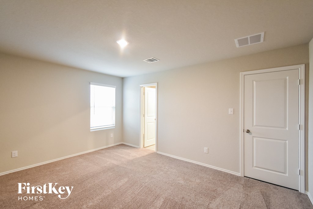 a master bedroom with a carpeted floor and a white door